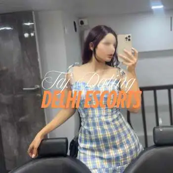 The girl is clicking her photo with her phone, she is wearing a white mix dress.